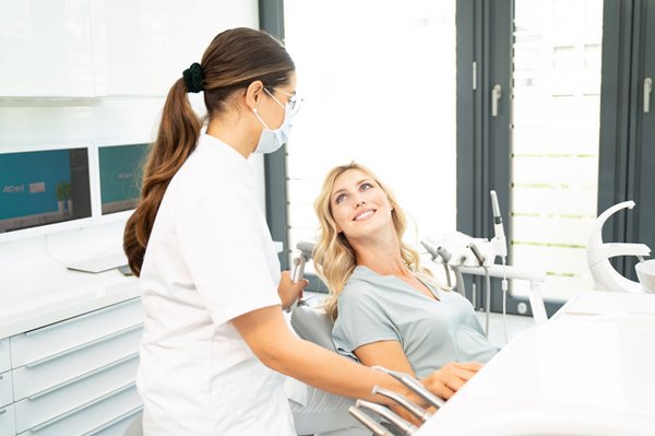 Zahn&auml;rztin schaut auf Patientin im Behandlungsstuhl