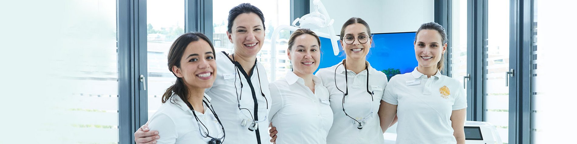 F&uuml;nf Zahn&auml;rztinnen stehen l&auml;cheln nebeneinander